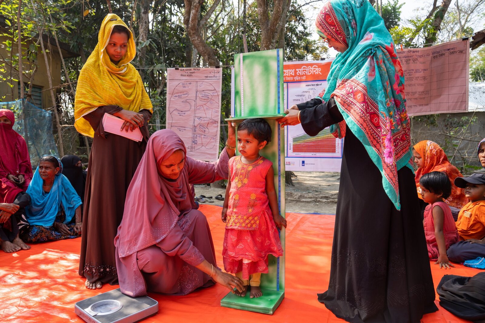 Growth monitoring in action: a child's height is measured at a community courtyard session in Barishal, Bangladesh.